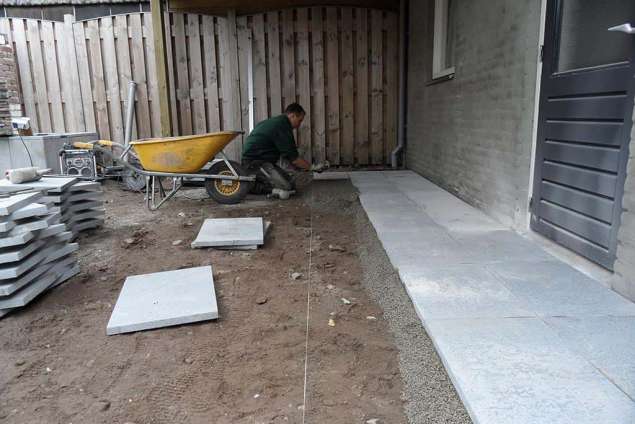 leggen van natuursteen op een gebroken puinbed, voor goede drainage van de stenen worden deze geplaats op split van 2/6. bestraten op gebroken puin verminderd opvriezing bij strenge vorst